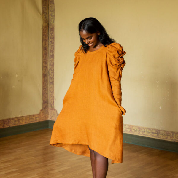 Jasmiina dress made in yellowish linen on a model. Photo by Laura Oja.