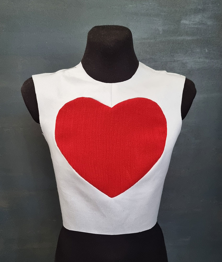 White top with a red heart shape in the front.