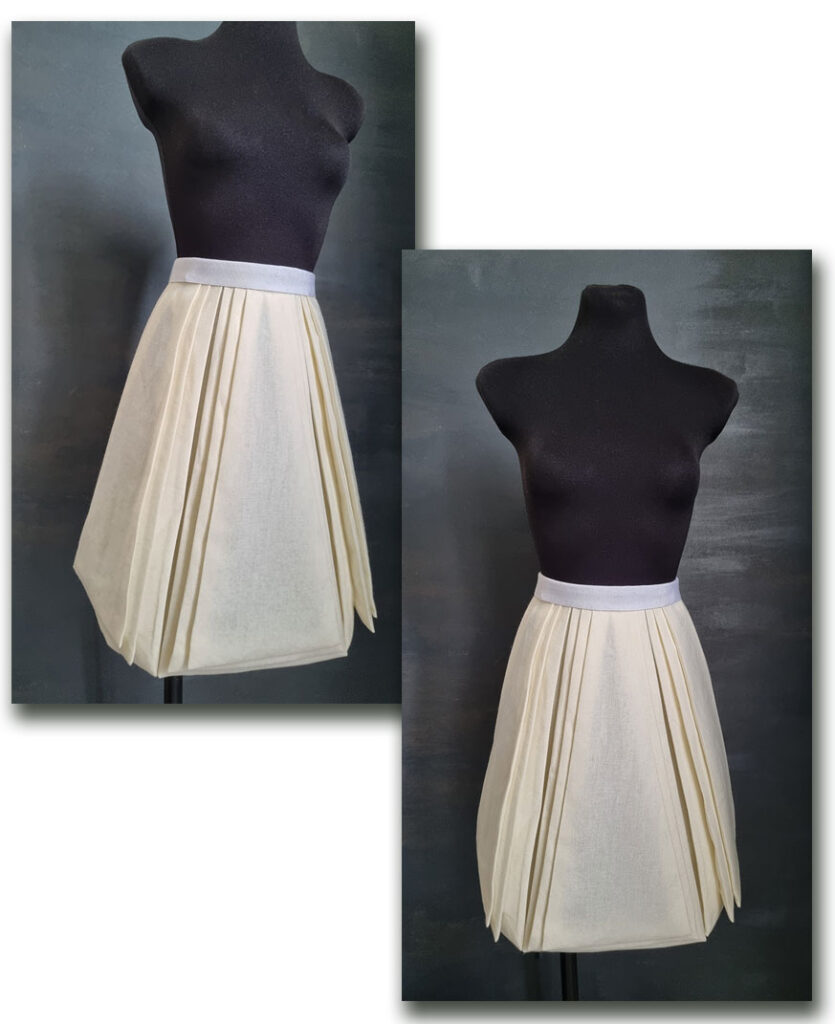 The panel skirt with accordion pleats around the panels on the mannequin.