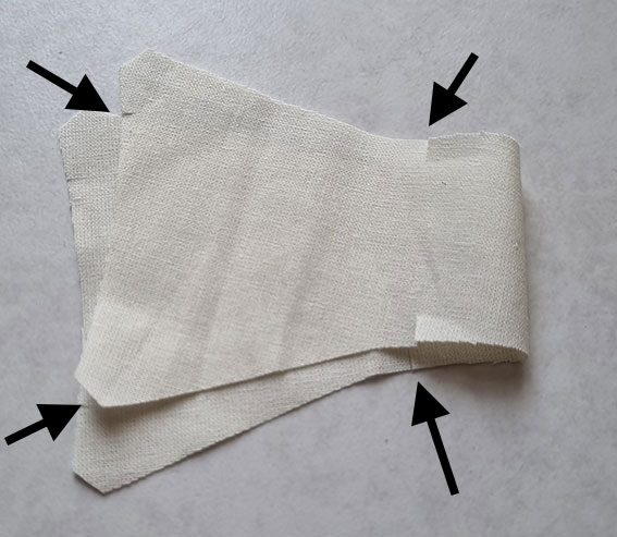 One knot piece cut on the fold with arrows pointing to the notches.