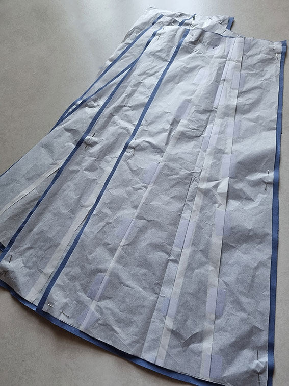 The skirt pieces in a pile with patterns still pinned.